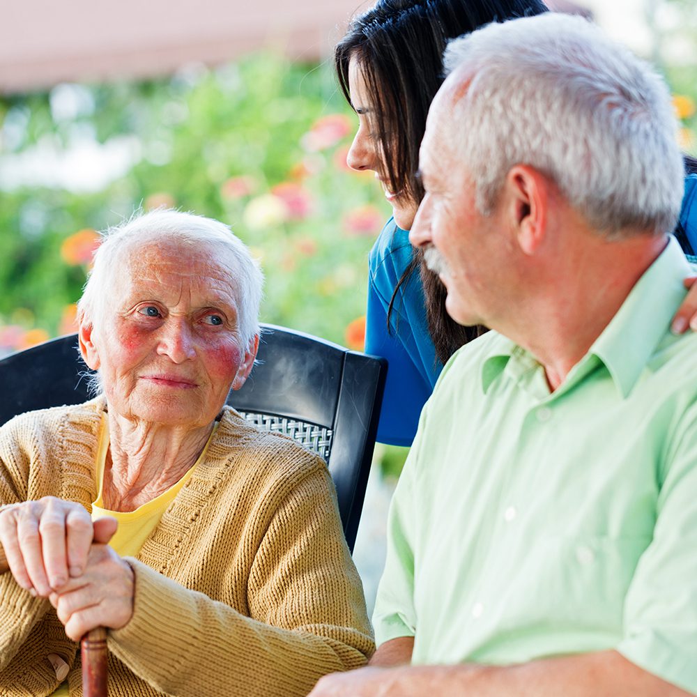 Elderly woman and man with caregiver.