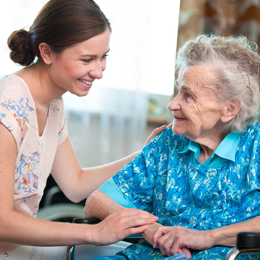 Young woman comforting elderly woman.