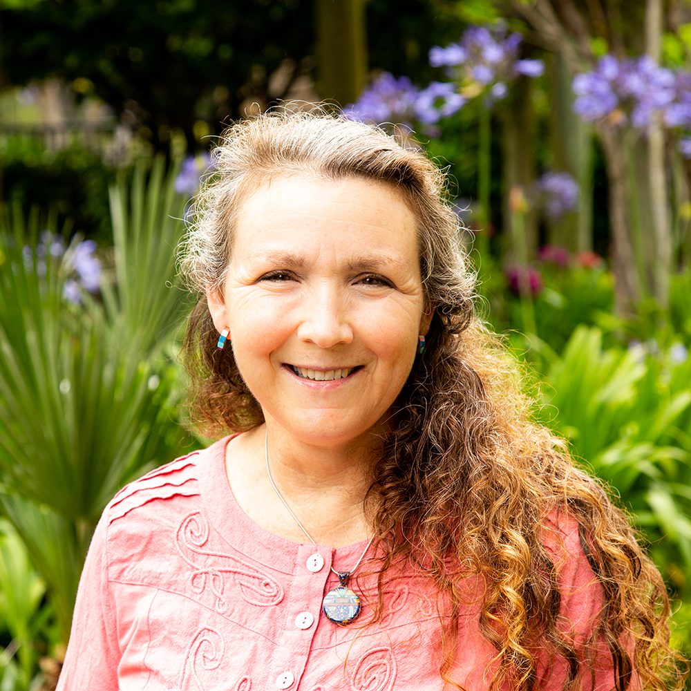 Smiling woman with long curly hair.